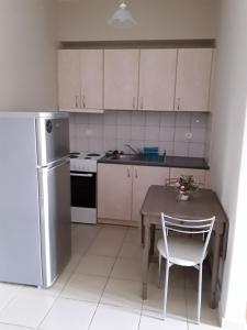 a small kitchen with a table and a refrigerator at G3 sea view appartment in Igoumenitsa