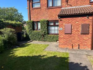 a brick house with a grass yard in front of it at Lakeside View 2, Perton Village in Wolverhampton
