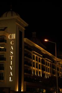 a building with a sign on the side of it at night at Castival Hotel in Side