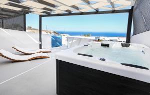 a bathroom with a soaking tub and a view of the ocean at Rafael' s Mediteranian Cave Suites in Firostefani