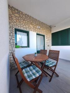 a wooden table and chairs on a patio at Apartments Ostojic in Tučepi