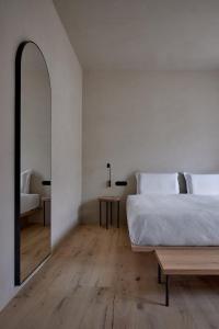 1 dormitorio con 1 cama grande y espejo en fink Restaurant & Suites, en Brixen