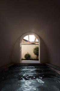 an indoor swimming pool with an archway and a window at fink Restaurant & Suites in Brixen