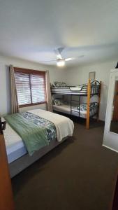 a bedroom with two bunk beds and a window at Abbey Beach Shack in Busselton