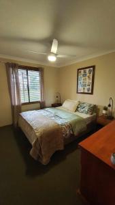 a bedroom with a large bed and a window at Abbey Beach Shack in Busselton