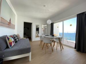 a living room with a couch and a dining room table at Hotel Cenit & Apts. Sol y Viento in Ibiza Town