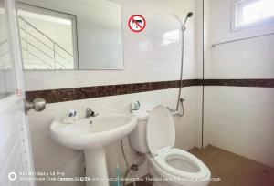 a bathroom with a toilet and a sink and a mirror at YYK Hostel 24H in Ban Khlong Krang