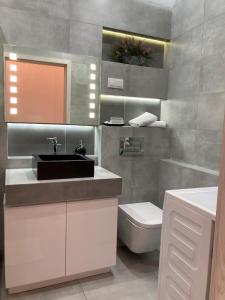 uma casa de banho com um lavatório e um WC em Apartament VIP em Cracóvia