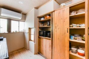 a kitchen with a wooden cabinet in a room at TSUDOYA 天王寺 in Osaka