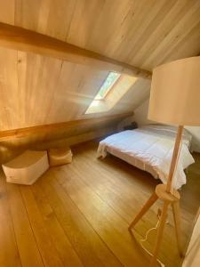 La Grangette de Paunac في Cazillac: غرفة نوم علوية بسرير ومصباح