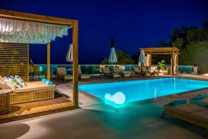 - une piscine avec des chaises et une terrasse la nuit dans l'établissement My Suite Boutique Hotel, à Parga