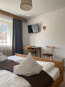 Habitación de hotel con 2 camas y escritorio en Ciasa Soreghina, en Colfosco