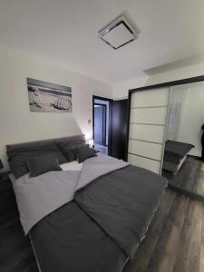 um quarto com uma cama grande e almofadas pretas em Flower Apartman Győr em Gyor