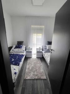 duas camas num quarto com uma porta aberta em Flower Apartman Győr em Gyor