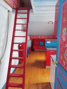 Una escalera roja en una habitación con sofá rojo en Les Camélias en Le Mont-Dore