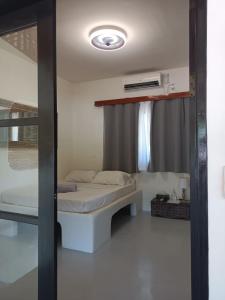a small bedroom with a bed and a window at Parrots Boutique Resort in San Vicente
