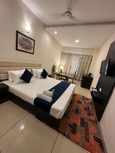 1 dormitorio con 1 cama grande con almohadas azules en JB Residency Zirakpur !! Top Rated & Most Awarded Property in Zirakpur, en Zirakpur