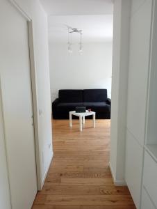 sala de estar con sofá negro y mesa en Il monolocale, en Bosisio Parini