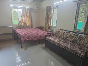 a living room with a couch and a table at Private Farm Stay in Pune