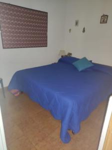 appartamento Cima في فيومالبو: سرير عليه بطانية زرقاء في الغرفة