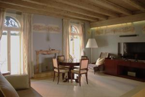 a living room with a table and chairs and a couch at Verona Luxury Flats , Piazza Erbe with balcony on main square in Verona