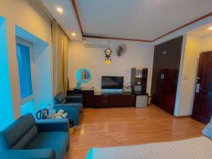 salon z 2 niebieskimi kanapami i telewizorem w obiekcie A25 Hotel - 61 Lương Ngọc Quyến w mieście Hanoi