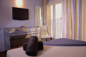 a hotel room with a bed and a tv on the wall at Verona Luxury Flats , Piazza Erbe with balcony on main square in Verona