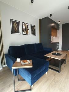 een woonkamer met een blauwe bank en een tafel bij GOLD APARTMENTS Capital Towers in Rzeszów