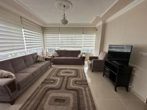 a living room with a couch and a television at Doğanın içinde eşsiz manzara in Cayeli