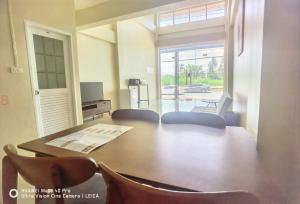 a dining room with a table and chairs and a television at YYK Hostel 24H in Ban Khlong Krang