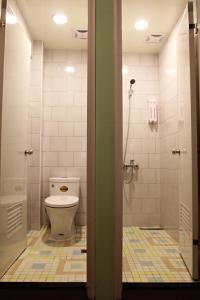 a bathroom with a toilet and a shower at Tourist Bunny Hostel in Tamsui