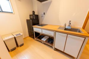 een keuken met een wastafel en een koelkast bij Irodori Hotel SAKURA in Fukuoka