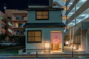 un edificio con una puerta con un cartel. en Irodori Hotel SAKURA, en Fukuoka