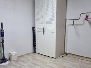 um armário branco com uma porta num quarto em Cooing em Chuncheon