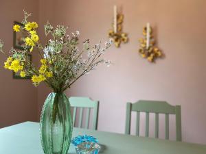 RamvikにあるSnibben Höga Kustenのテーブルの上に黄色い花を咲かせた緑の花瓶