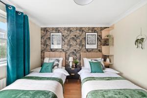 ロンドンにあるStunning Central London 2 Bed Parking & Gardenの青いカーテンが備わる小さな部屋のベッド2台