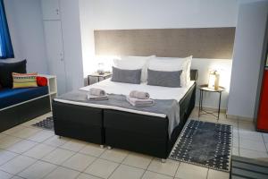 - une chambre avec un grand lit et 2 serviettes dans l'établissement Adriana's downtown studio-parking lot included, à Patras