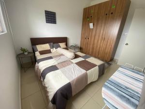 Schlafzimmer mit einem Bett und einem Holzschrank in der Unterkunft Alanis D'semporna Homestay in Sepang