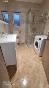 La salle de bains est pourvue d'une douche et d'un lave-linge. dans l'établissement Apartments AnaIvana, à Trogir