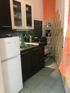 a kitchen with black cabinets and a white refrigerator at Apartments Lavandis in Murter