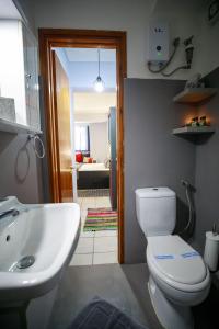 La salle de bains est pourvue de toilettes blanches et d'un lavabo. dans l'établissement Adriana's downtown studio-parking lot included, à Patras