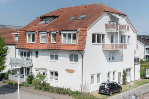 un edificio blanco con techo rojo en Appartementhaus Christel, en Grömitz