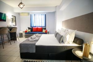 a bedroom with a large bed and a couch at Adriana's downtown studio-parking lot included in Patra