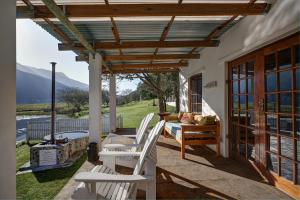 a patio with chairs and a table and a grill at Somerset Gift Getaway Farm in Swellendam
