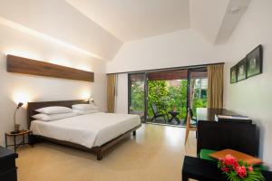 1 dormitorio con cama blanca y balcón en Haadson Resort - Khaolak, Phangnga, en Khao Lak