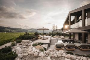 een huis met een patio met stoelen en parasols bij Luxury Chalet Alpurio in Selva di Val Gardena