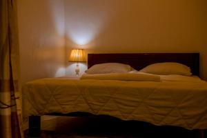 ein Schlafzimmer mit einem Bett mit einer Lampe in der Unterkunft Mwiza in Kigali