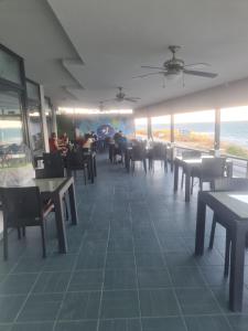 a dining room with tables and chairs and the ocean at Choras Butik Otel in Şarköy