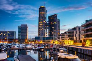 a group of boats docked in a harbor with buildings at Marina View - Yacht Park Premiere in Gdynia