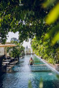 a woman in a swimming pool at a resort at The Ritz - Carlton, Bangalore in Bangalore